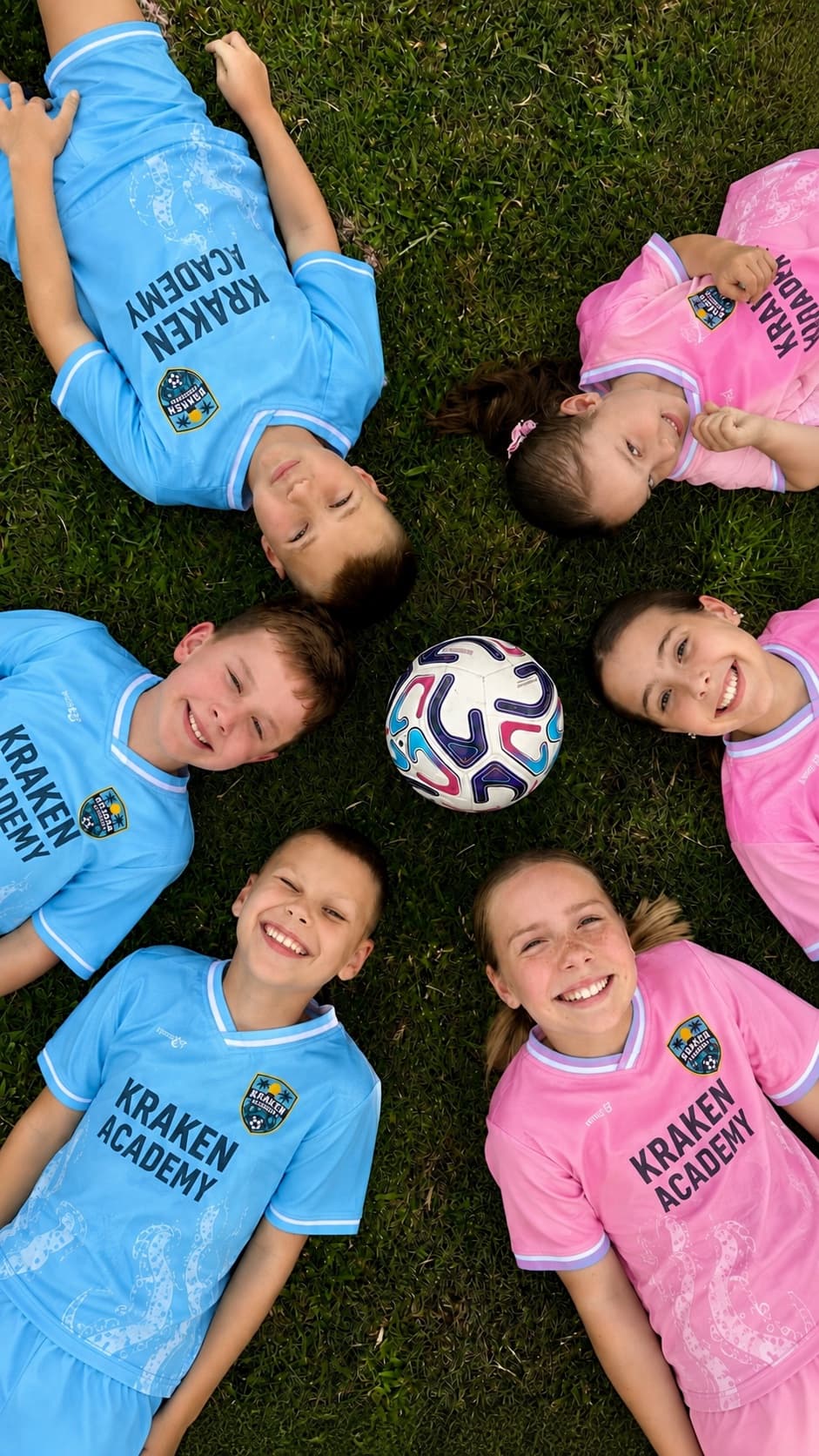 Six Kraken Academy players lying in a circle on the grass around a ball, seen from above